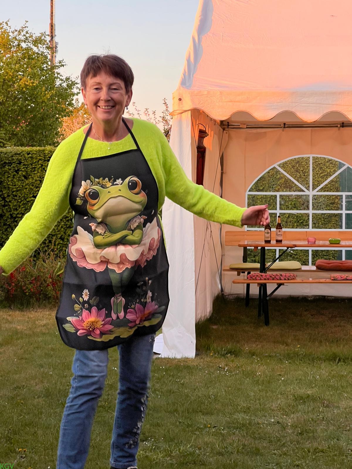 Gartenfreundin mit Frosch-Schürze posiert lachend vor dem Festzelt