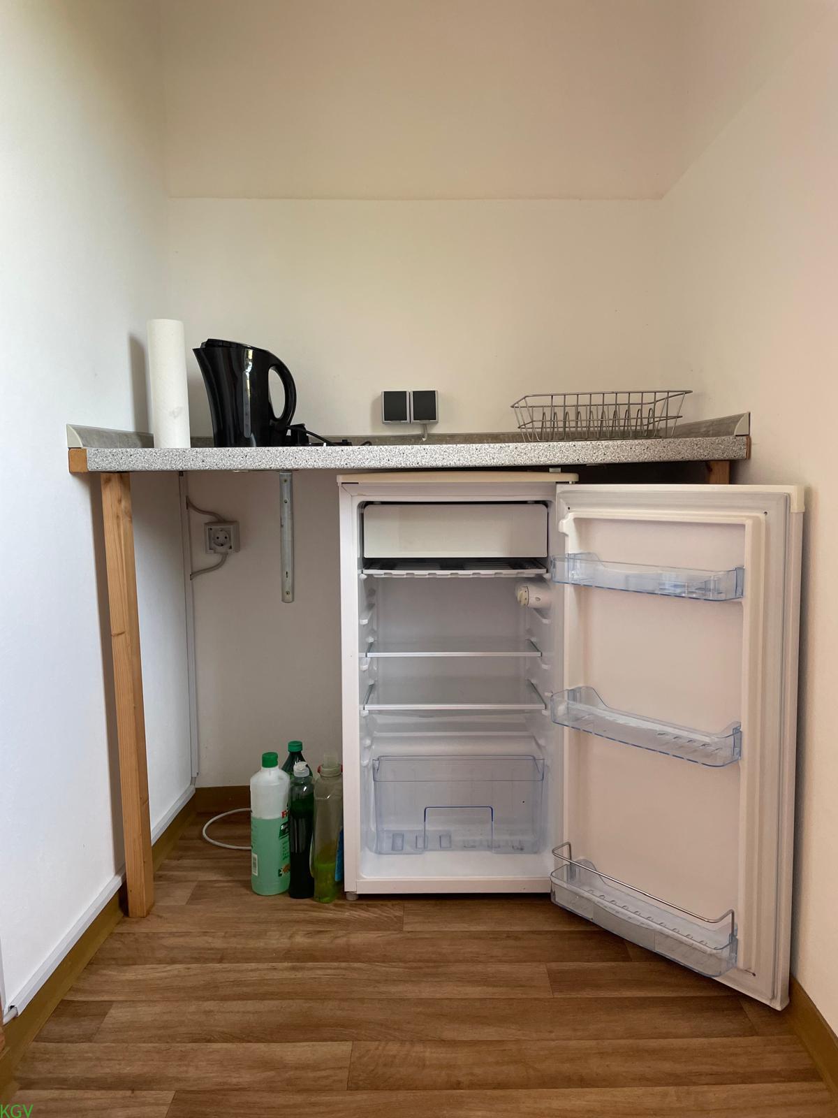 Kleine Küchenzeile mit Kühlschrank und Wasserkocher
